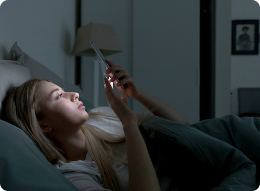 세스코만의 IoT로 스마트폰으로 침실에 누워서 집환경을 관리하는 여성